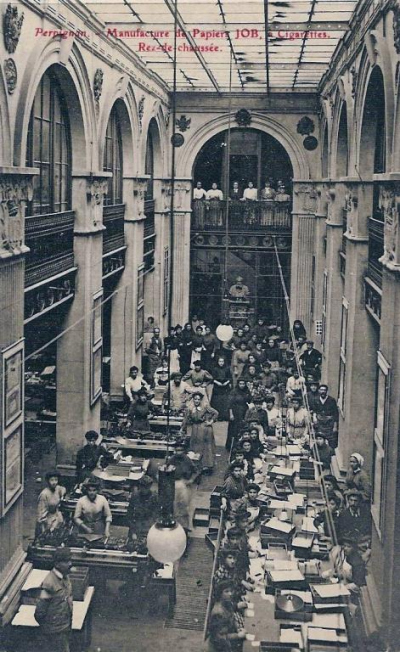 Photo:dans un grand hall ,avec colonnes et arcades, des ouvrières   travaillent sous le regard du buste de Joseph  BARDOU 
