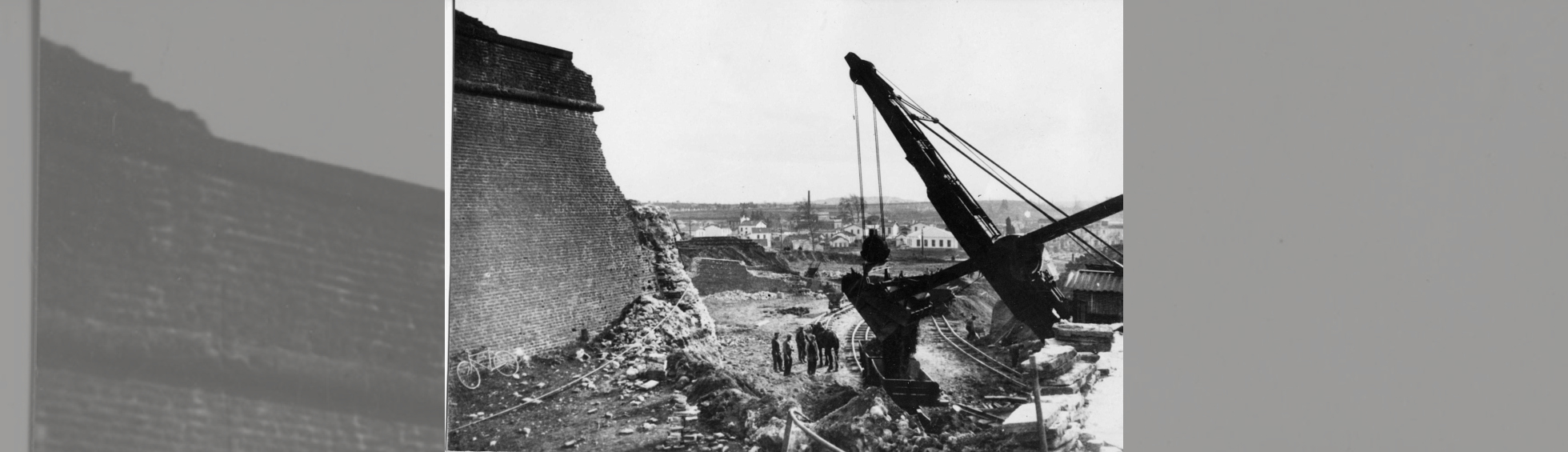 une énorme pelle est entrain de charger un wagonnet sur rail pour evacuer les matériaux de démolition des remparts